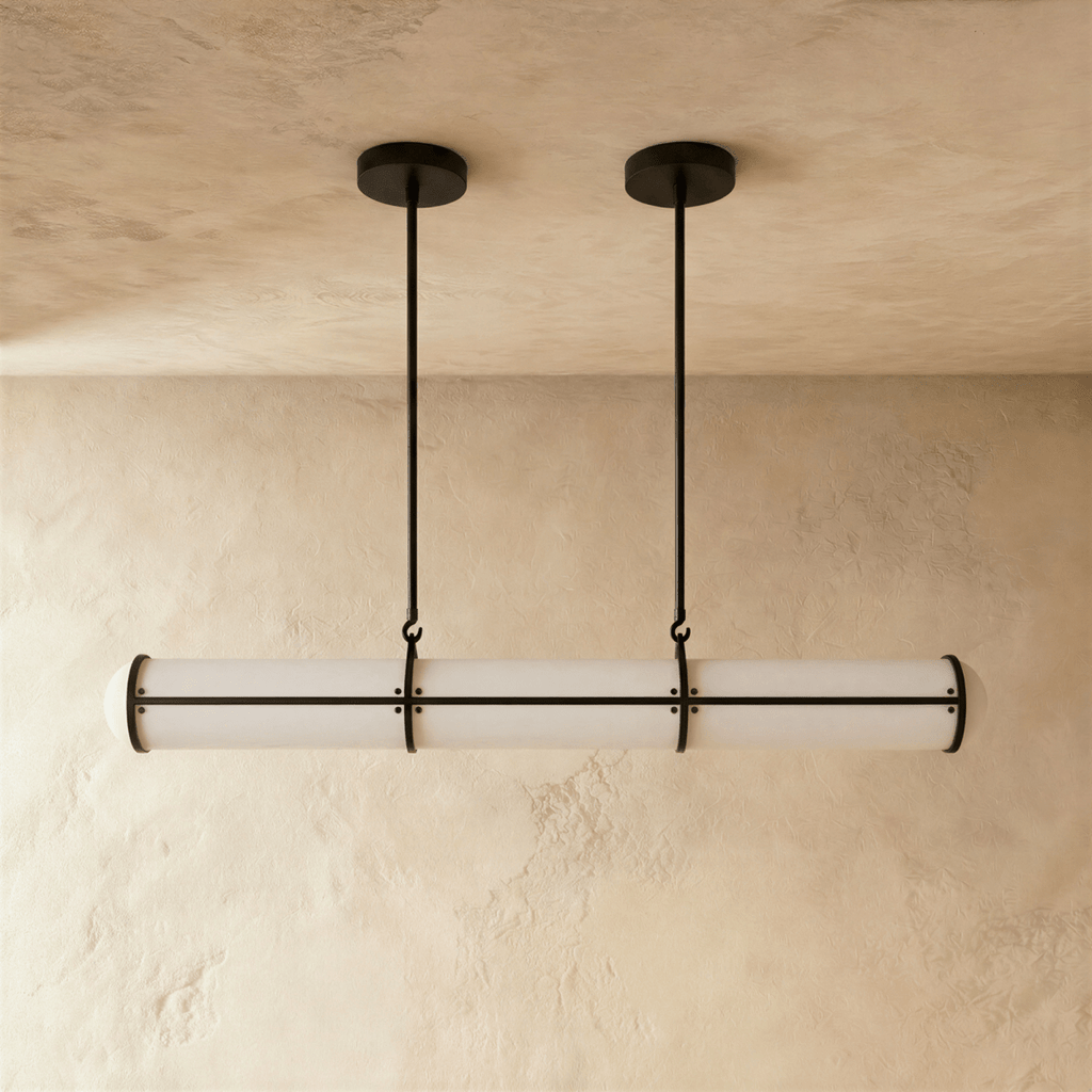 Clérachic black-banded opal tube pendant on two slim rods, shown at its shorter length against a warm plaster backdrop.