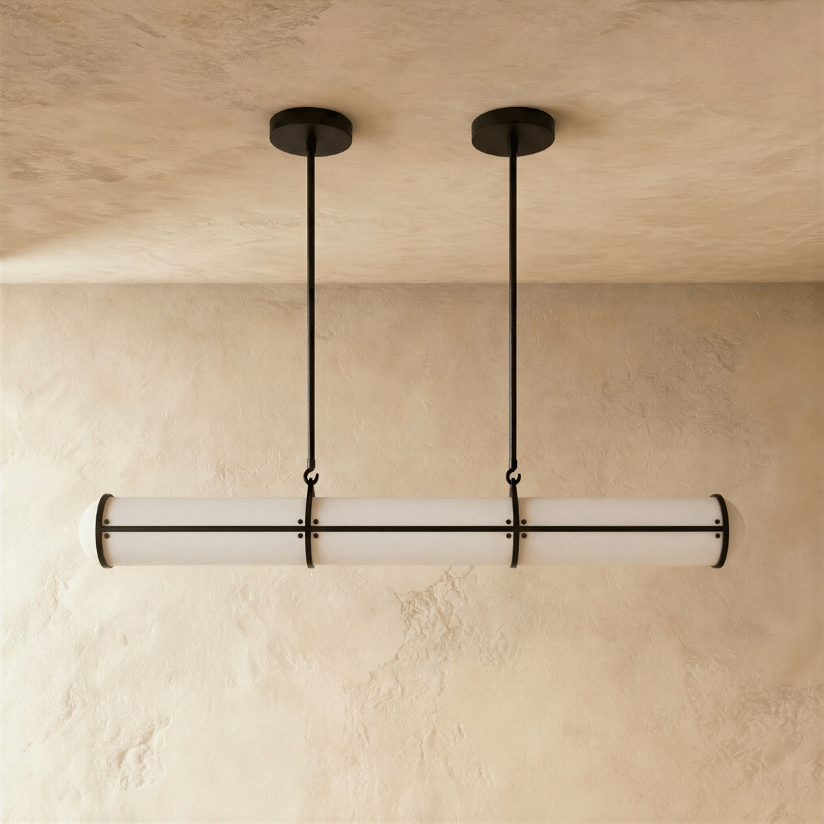 Clérachic black-banded opal tube pendant on two slim rods, shown at its shorter length against a warm plaster backdrop.