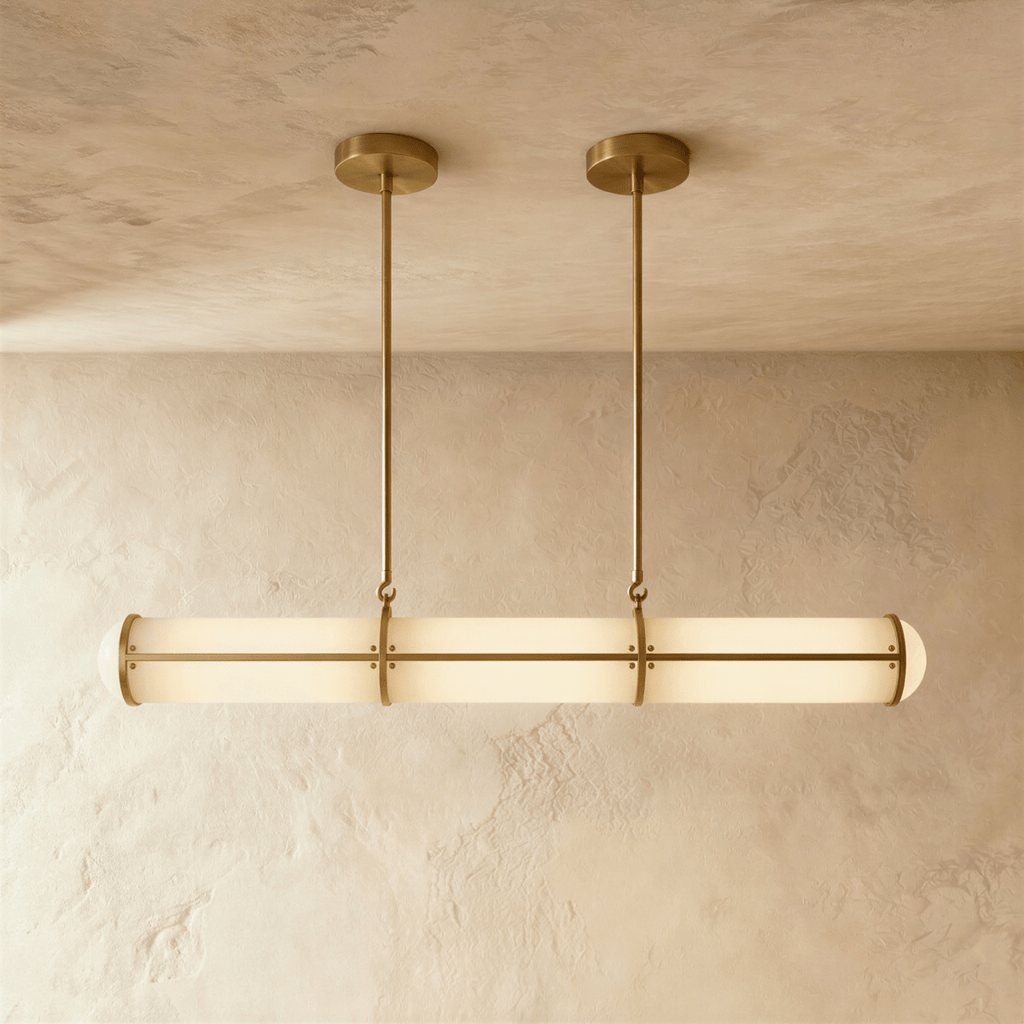 Clérachic opal tube pendant in a gold finish, its slim rods and ceiling plates echoing the banded frame over a plaster wall.