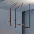Close-up framing of three red bars from this Clérachic linear pendant light, glowing along their lower edges against a blue-grey wall.