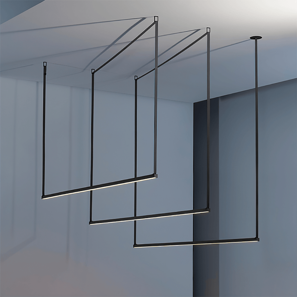 Three black bars from this Clérachic linear pendant light hang in a staggered frame in a blue-grey room, lit along their undersides.