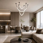 Black Clérachic multi-tube pendant over an open-plan living area, with a round dining table and a sectional in the background.