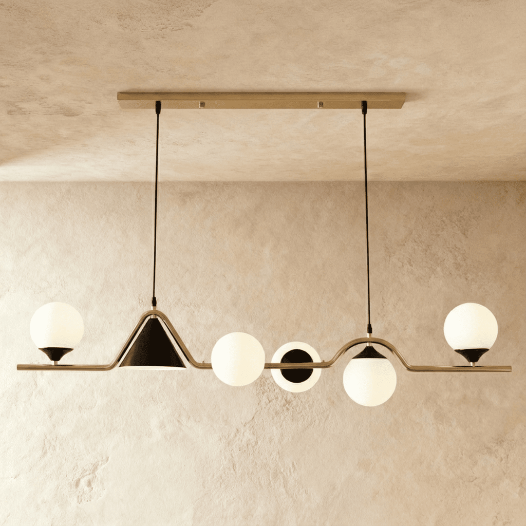 Clérachic wavy linear pendant with a gold bar, milk white glass globes and a black cone shade, studio shot on a limewash wall.