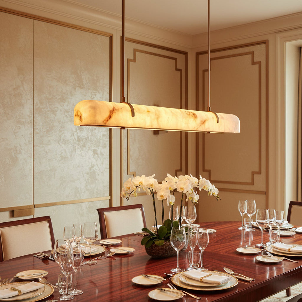 Close view of this Clérachic linear pendant's marbled shade glowing above a polished table laid with glasses and orchids.