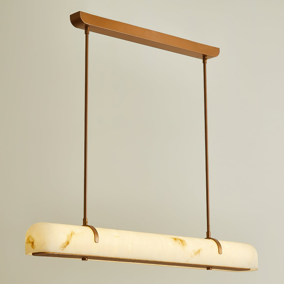 Lit from within, this Clérachic linear pendant shows its white shade glowing yellow along its length, against a warm cream wall.