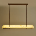 The glowing shade of this Clérachic linear pendant, straight on, with two slim rods and a copper-toned canopy above it.