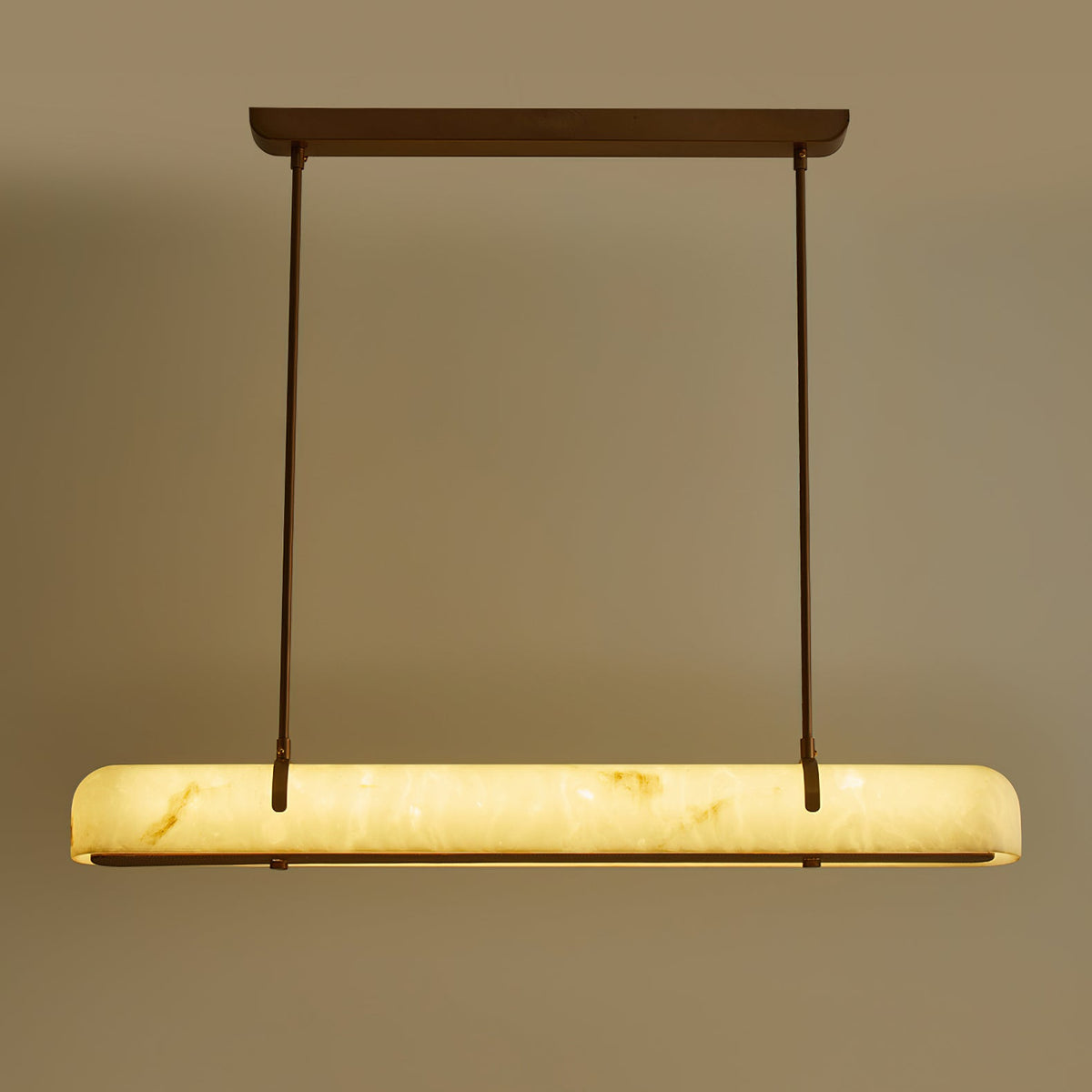 The glowing shade of this Clérachic linear pendant, straight on, with two slim rods and a copper-toned canopy above it.