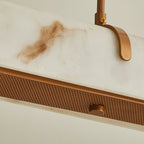 Close view of the marbled shade, curved copper-toned bracket and fine-mesh underside on this Clérachic pendant.