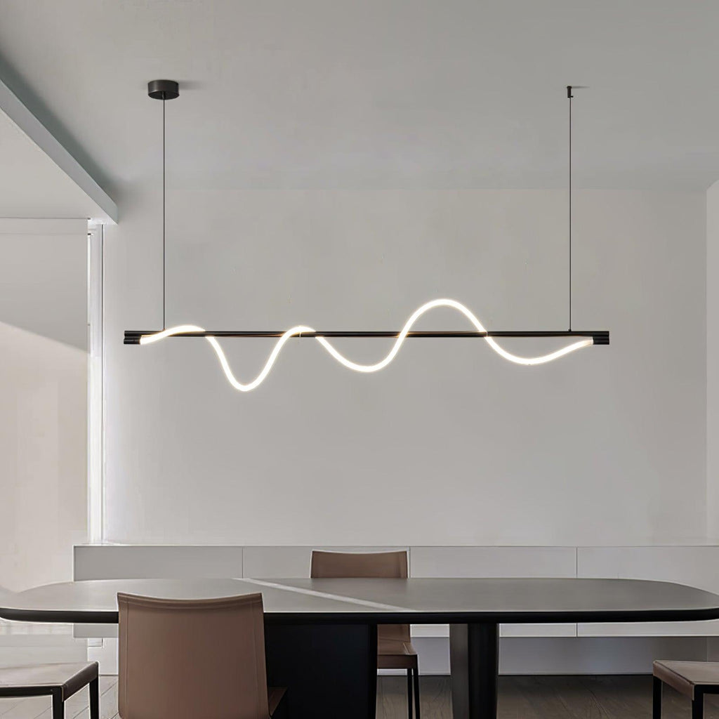 Clérachic linear pendant with a black bar and glowing white wave, over a dark table and tan leather chairs.