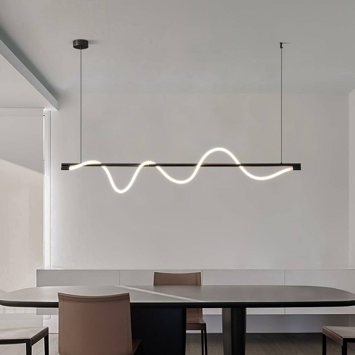 Clérachic linear pendant with a black bar and glowing white wave, over a dark table and tan leather chairs.