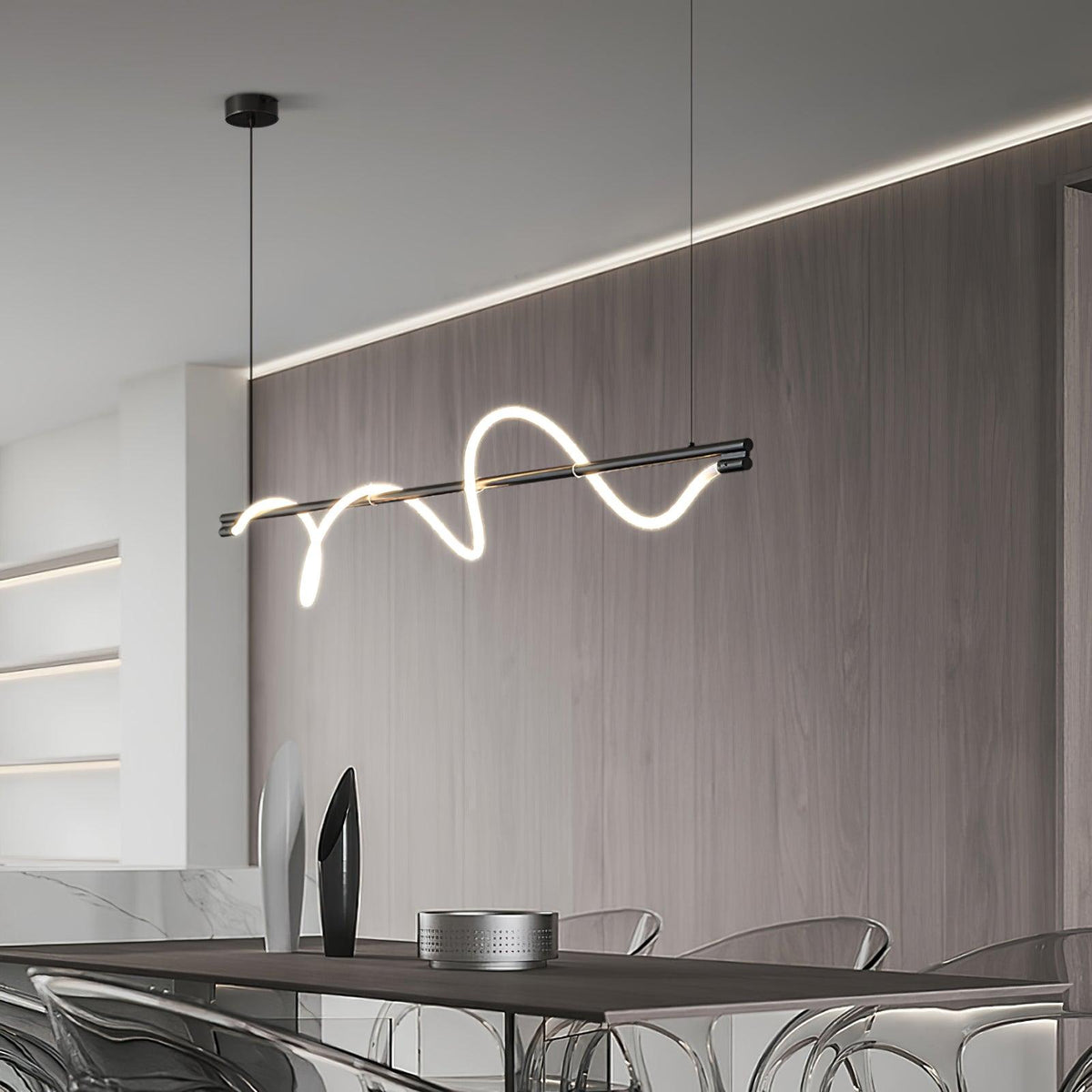 Black Clérachic linear pendant hangs at a slant in front of a wood-panelled wall with a glowing cove light.