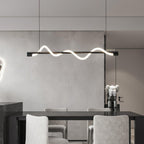 Black Clérachic linear pendant above a black dining table with pale chairs and a small figure on a shelf.
