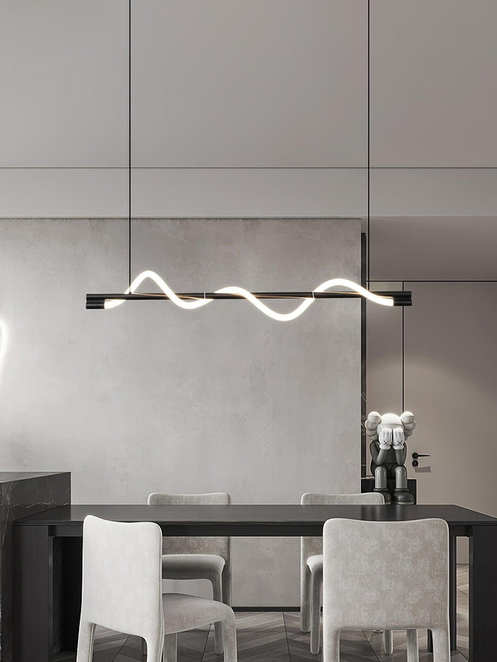 Black Clérachic linear pendant over a dark table with pale upholstered chairs, in a calm grey room.