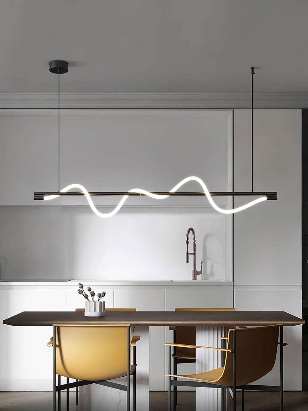 Clérachic black linear pendant above a walnut table and mustard chairs, in a kitchen with a copper tap.