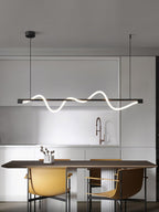 Clérachic black linear pendant above a walnut table and mustard chairs, in a kitchen with a copper tap.