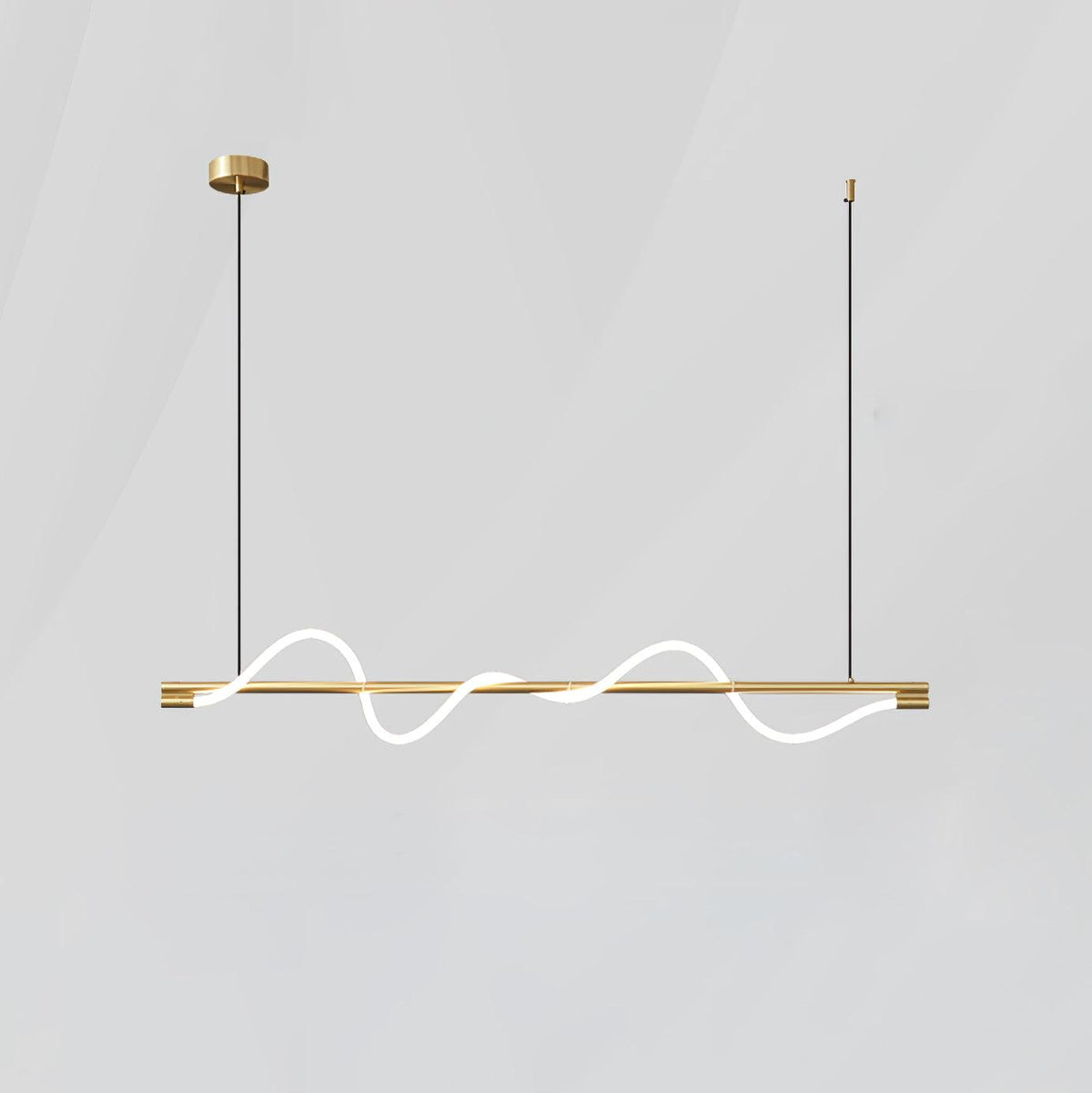 Brass Clérachic linear pendant with two glowing waves, hanging on thin cords against a light grey wall.
