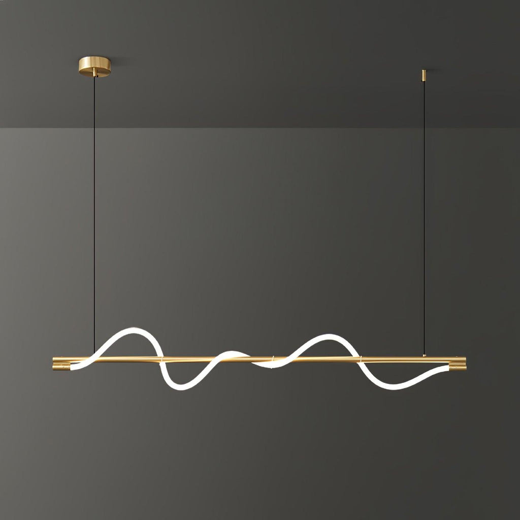 Brass Clérachic linear pendant lit with a deep wave, on a brass canopy against a dark grey wall.
