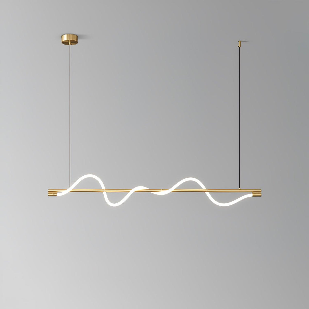Clérachic brass linear pendant with glowing waves, seen against a mid-grey backdrop.