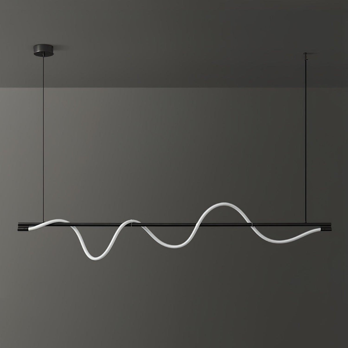 Black Clérachic linear pendant with a white wave that is lit softly, against a dark wall.
