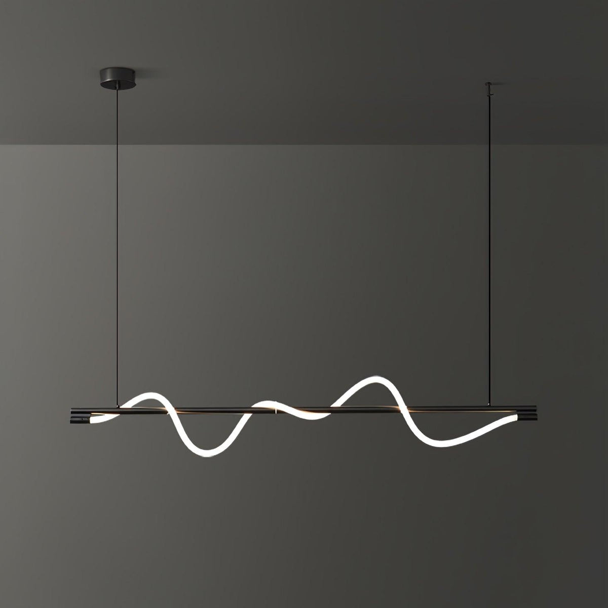 Black Clérachic linear pendant with a tilted glowing wave, seen slightly from the side against a dark wall.