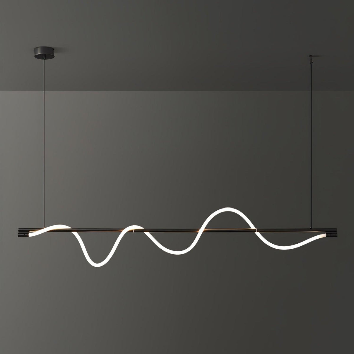 A black Clérachic linear pendant lit with a long, deep wave, hanging in front of a charcoal wall.
