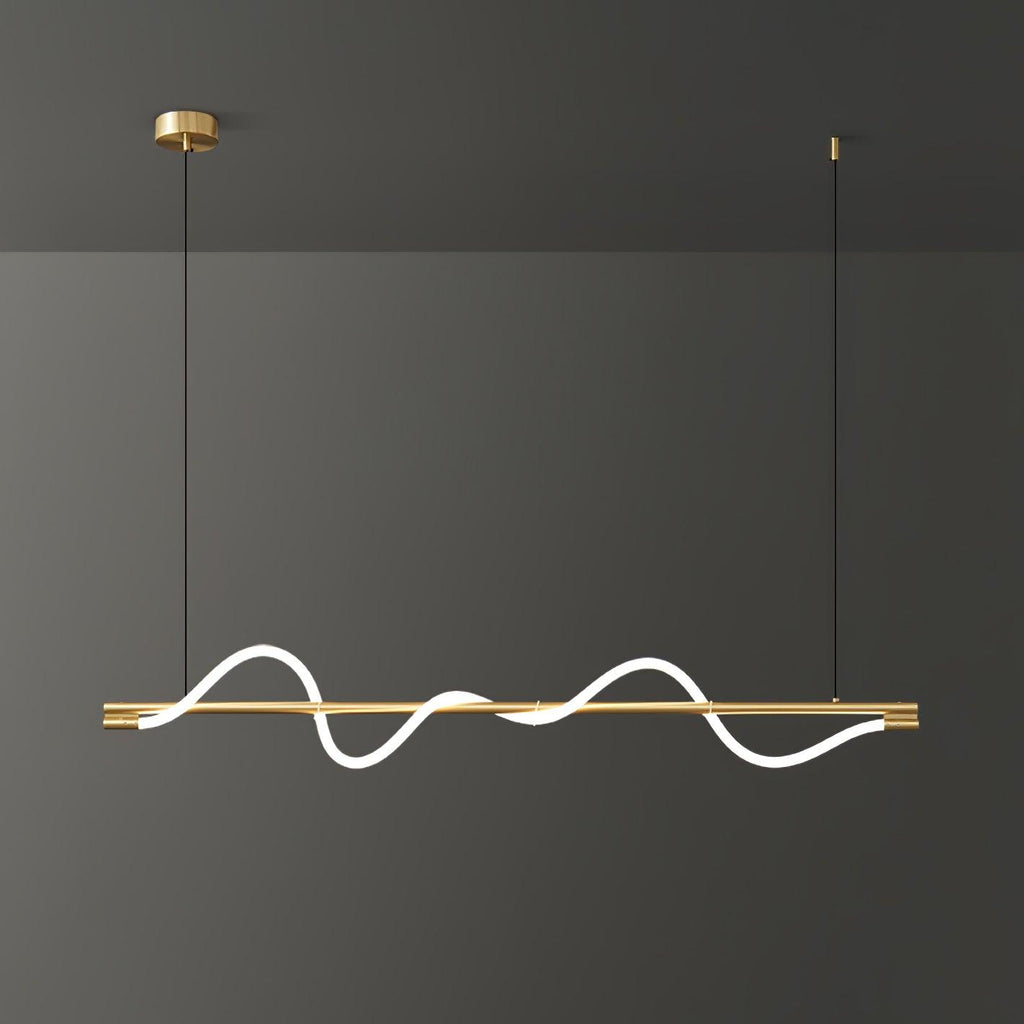 Brass Clérachic linear pendant with a bright wave and a brass canopy, in front of a dark grey wall.