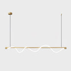 Long brass Clérachic linear pendant with a glowing wave, on a brass canopy against a pale backdrop.