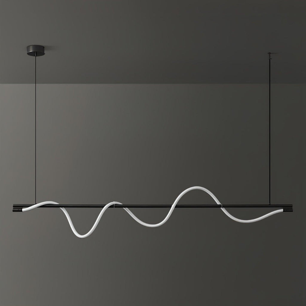 Wide black Clérachic linear pendant with an unlit white silicone wave, against a dark grey wall.