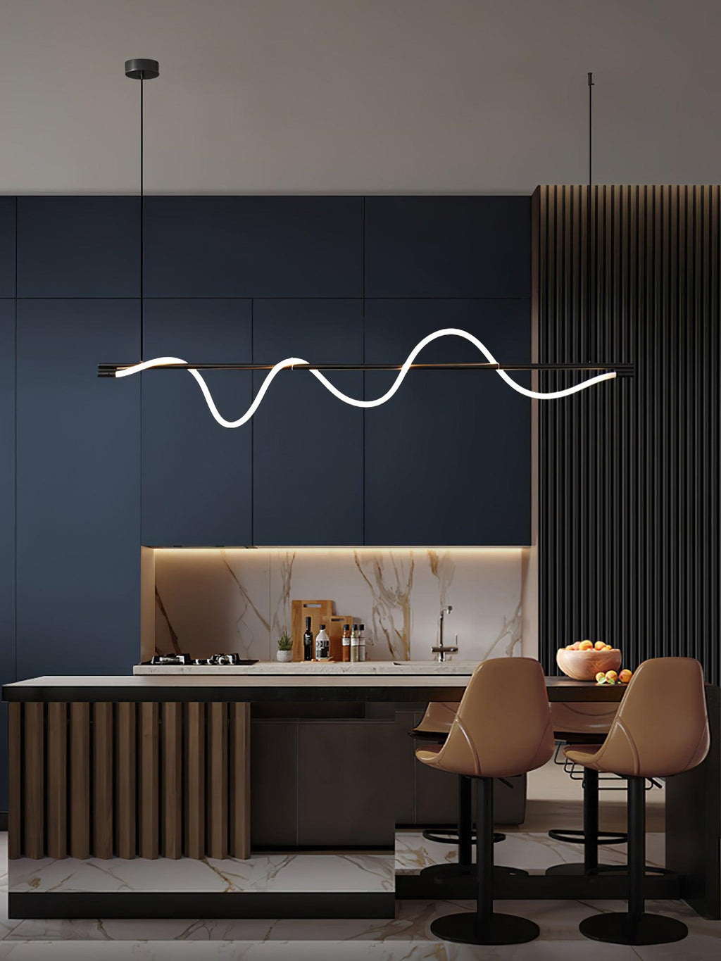 Black Clérachic linear pendant above a kitchen island with tan bar stools, against navy cabinets and a marble splashback.
