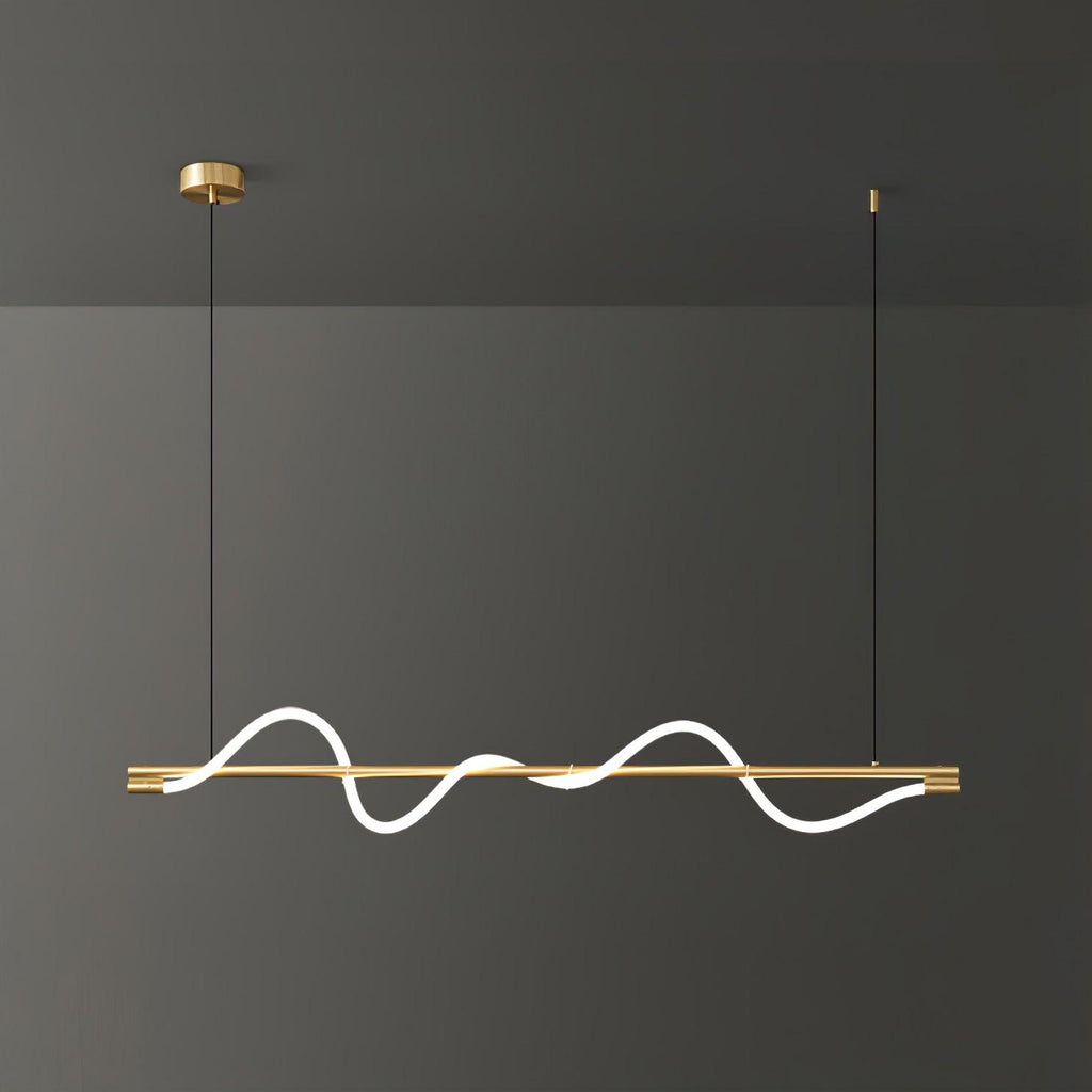Brass Clérachic linear pendant with a bright wave, filling the frame against a dark grey wall.