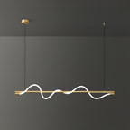 Brass Clérachic linear pendant with a bright wave, filling the frame against a dark grey wall.
