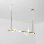 Looking up at a brass Clérachic linear pendant with a glowing wave, hung from a white ceiling.
