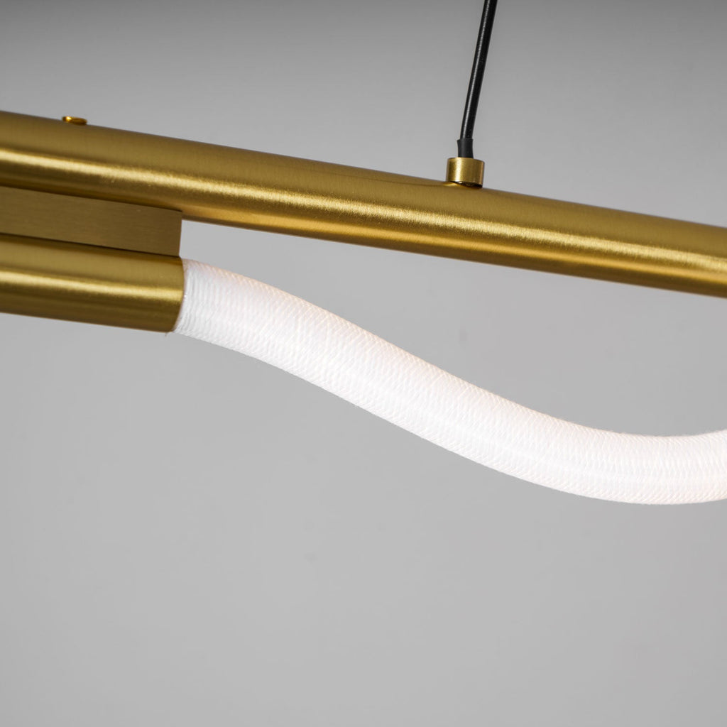 Close view of the brass bar, end cap and the textured white silicone of this Clérachic linear pendant.