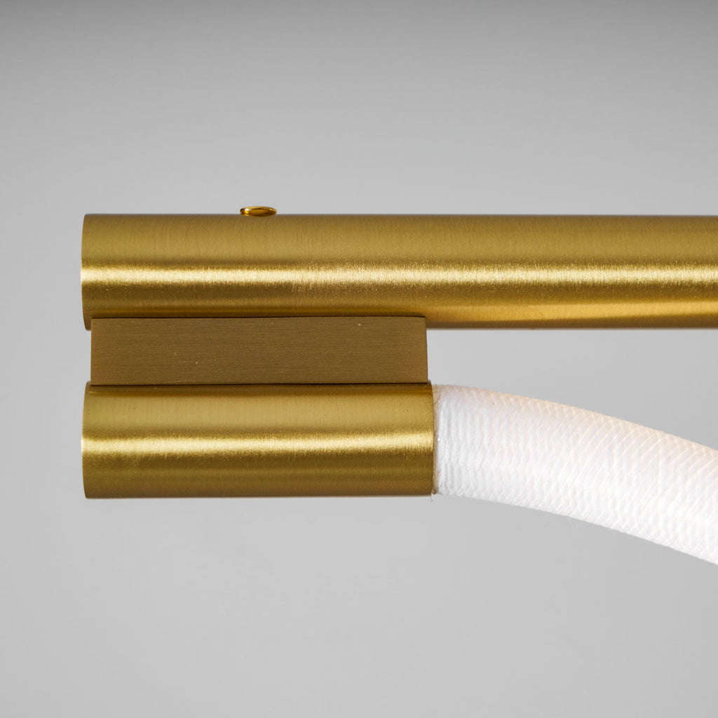 Close view of the brushed brass end cap and the silicone line entering it on this Clérachic pendant.