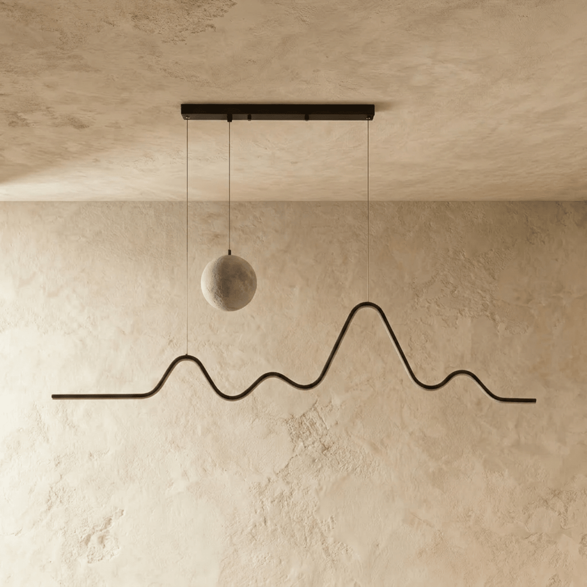 Clérachic 120 cm black pendant switched off, showing the grey moon-textured globe and the mountain-ridge metal line on limewash.