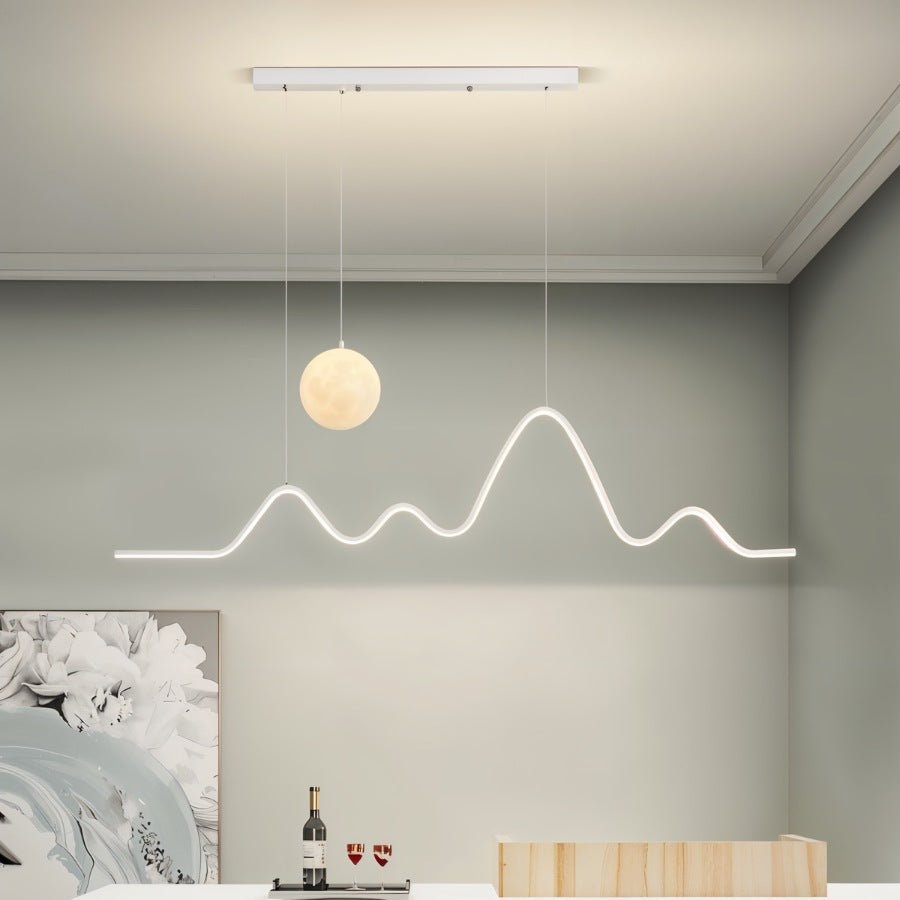 Clérachic 120 cm white moon-and-mountain pendant lit in a grey dining room with coved ceiling, floral artwork and a wine tray.