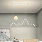 Clérachic 120 cm white moon-and-mountain pendant lit in a grey dining room with coved ceiling, floral artwork and a wine tray.