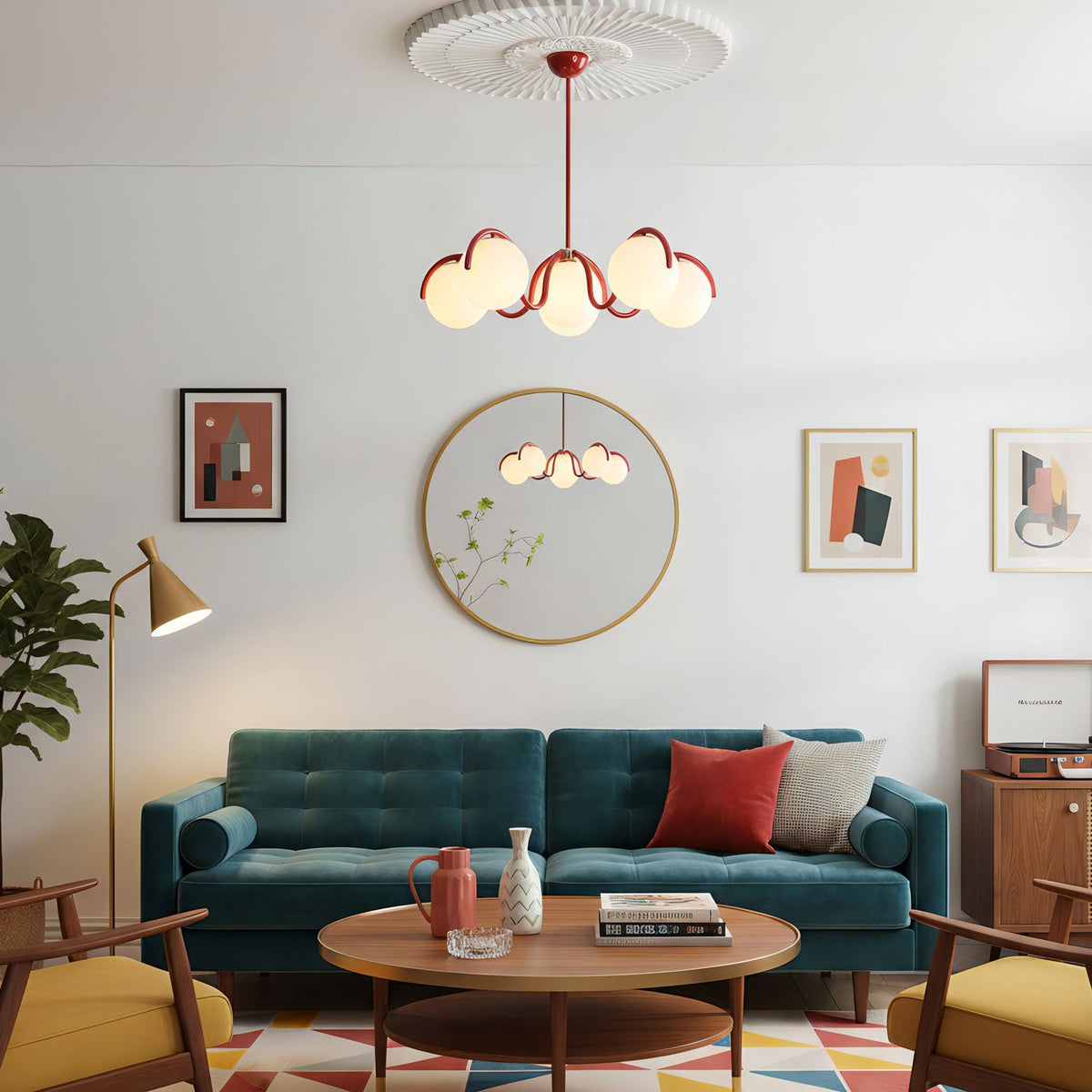 A red Clérachic globe chandelier hung in a living room with a teal sofa, a round mirror and a wooden coffee table.