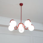 A red Clérachic chandelier from below with a round red canopy, its globes lit warm against a white cornice.