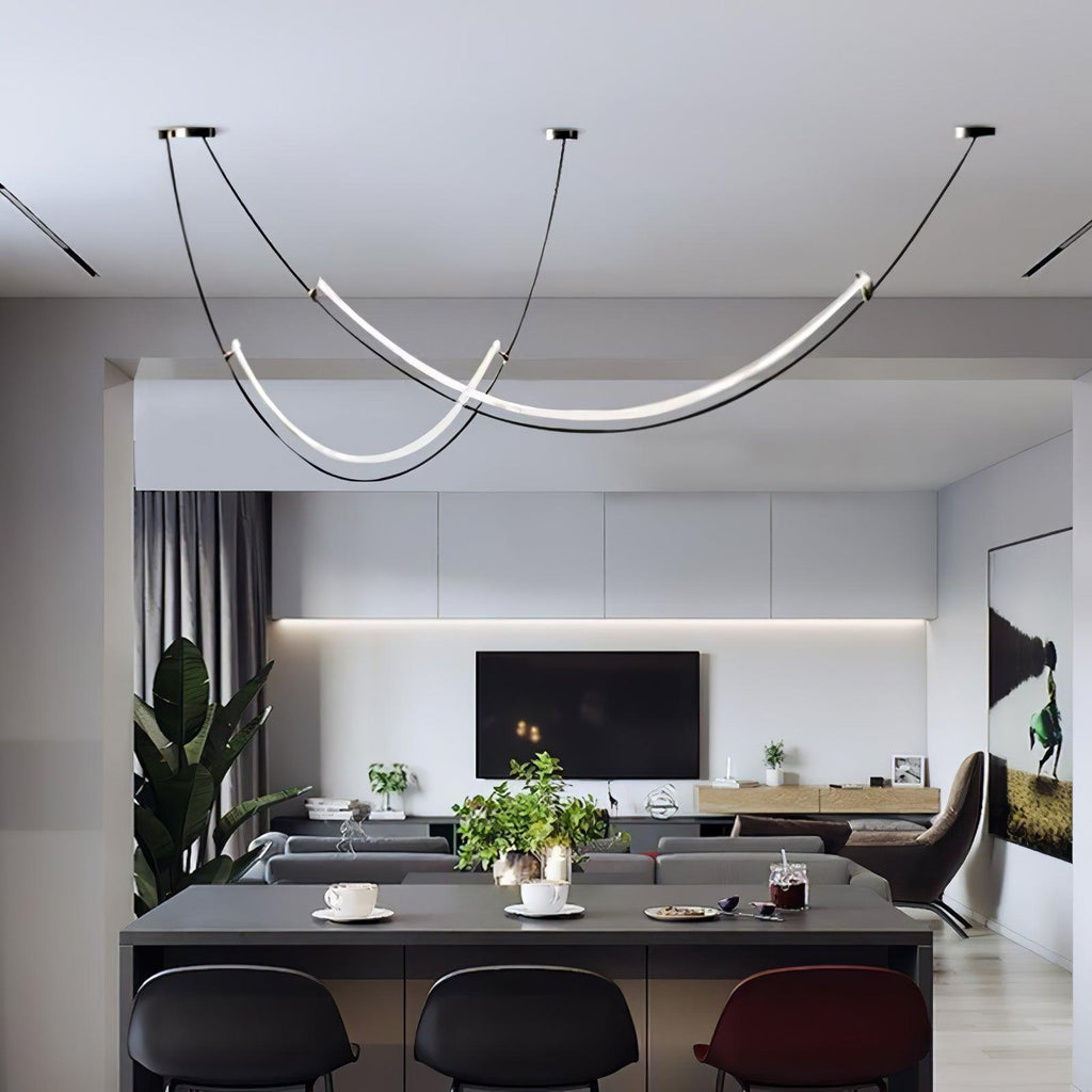 This Clérachic pendant over an open-plan kitchen island with black bar stools, the living area and television beyond.