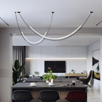 This Clérachic pendant over an open-plan kitchen island with black bar stools, the living area and television beyond.