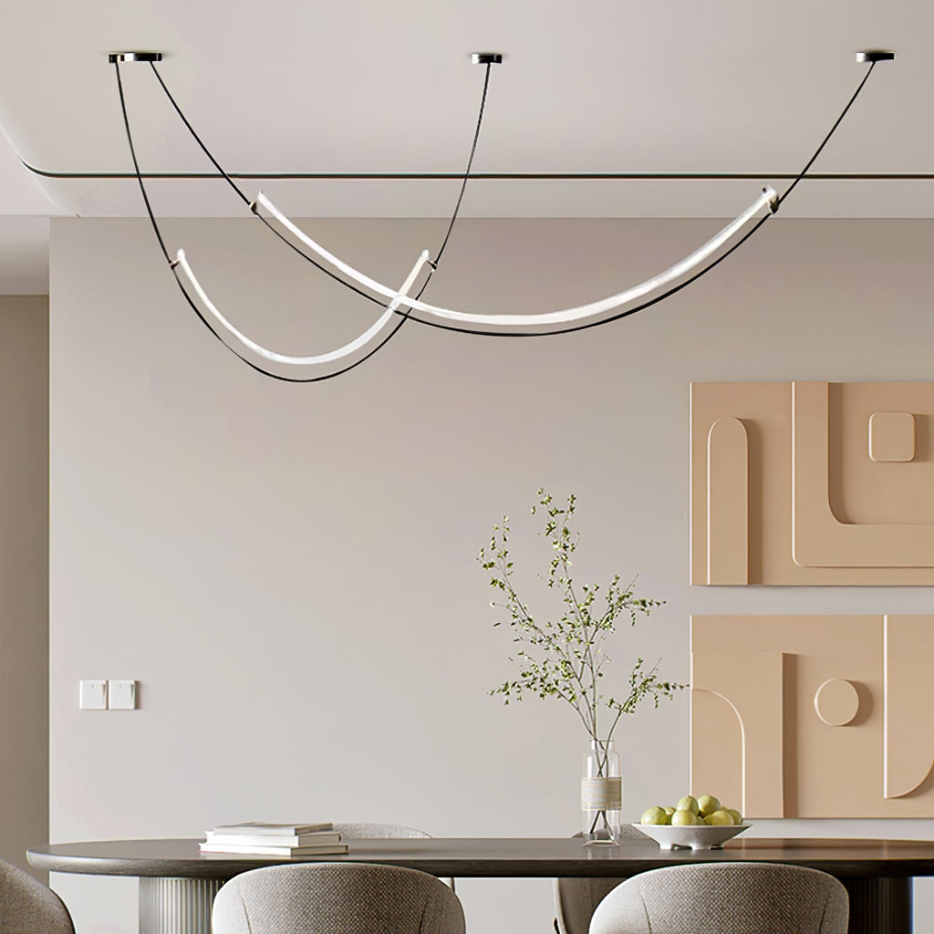 Clérachic pendant above an oval dining table with a fruit bowl and sprigs in a vase, in front of two peach wall reliefs.