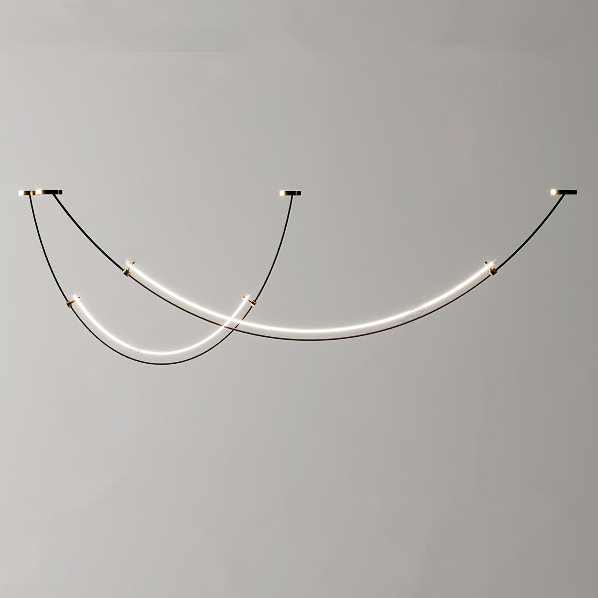 Unlit view of this Clérachic pendant against a plain grey wall, black cables running to three canopies with a gold trim.