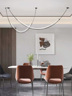 Narrow view of this Clérachic pendant over a white table with rust-orange chairs and an abstract print, in a recessed ceiling bay.