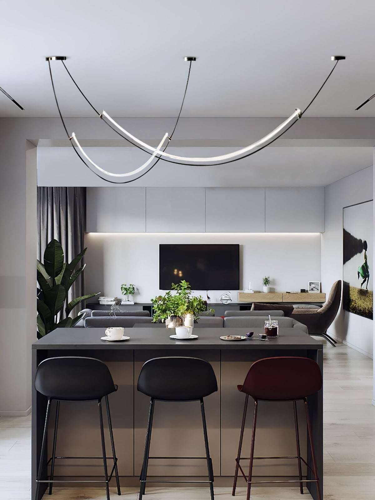 This Clérachic pendant seen from further back, above a dark kitchen island with three bar stools and a living room beyond.