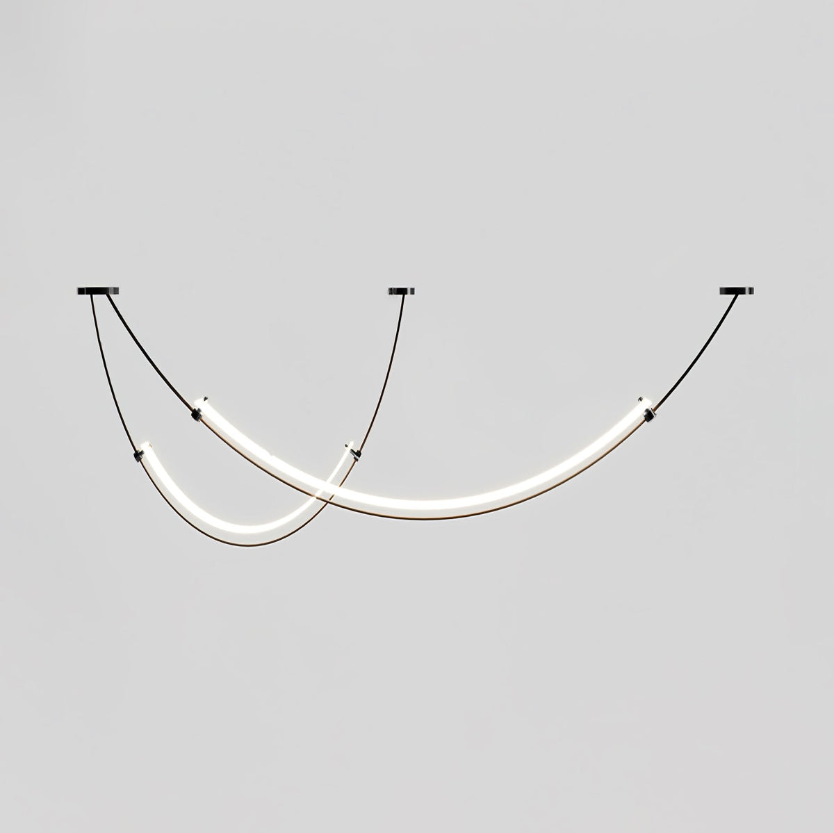 This Clérachic pendant lit against a grey backdrop, shown a little closer than before, with a gold collar at the end of each bar.