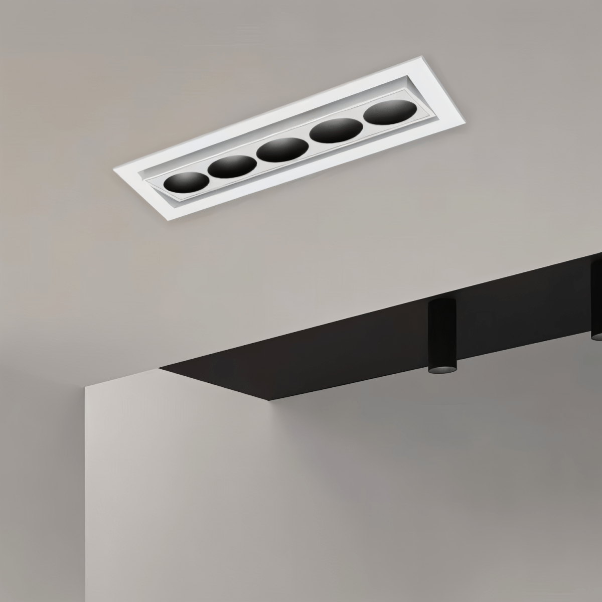 Clérachic white recessed downlight with five black reflectors on a tilting inner bar, fitted into a pale ceiling beside a dark bulkhead.