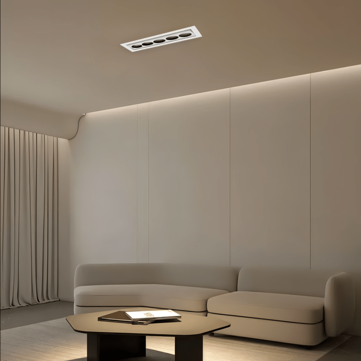 Clérachic five-reflector white recessed downlight in a taupe living room ceiling, with a cove glow above panelled walls and a low sofa.