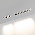 Clérachic white recessed downlights, a five-reflector and a ten-reflector size side by side, lit warm and washing a pale wall below.