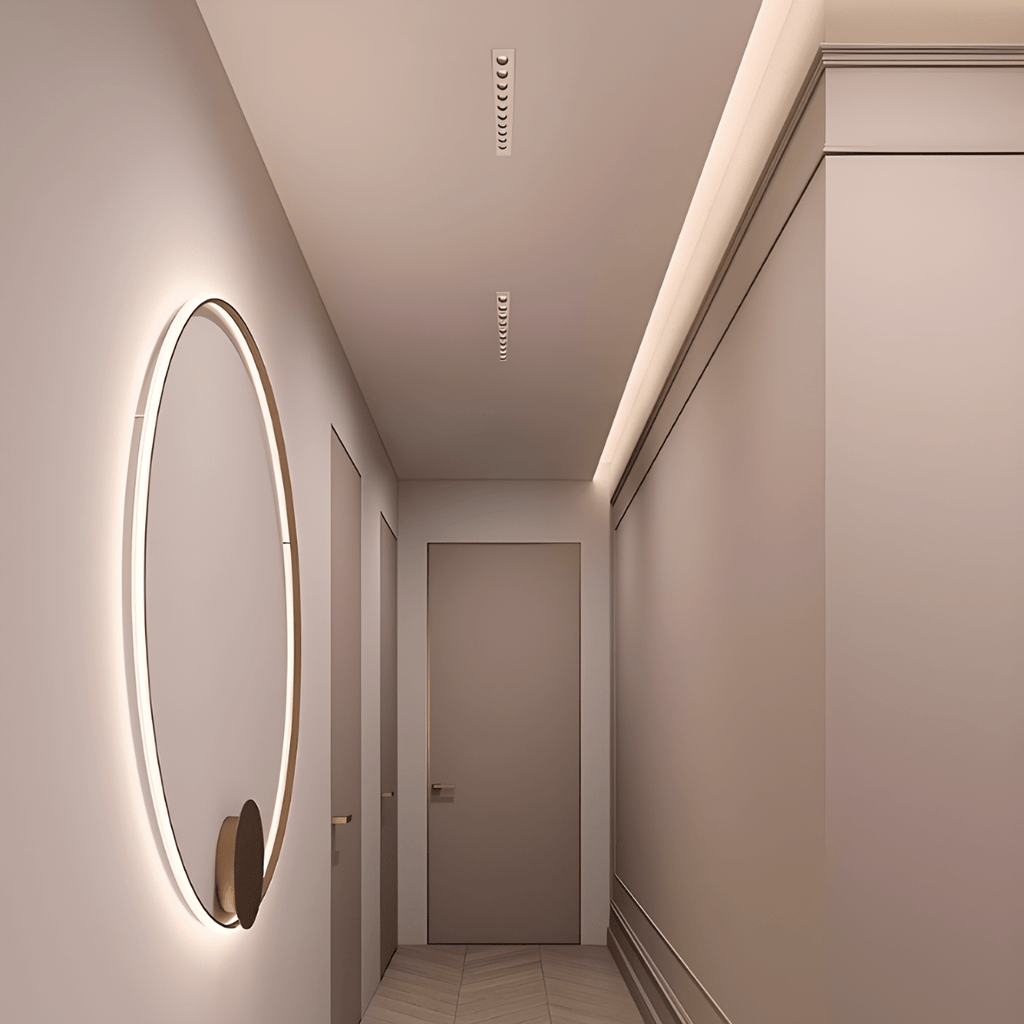 Clérachic white recessed linear downlights set along a narrow hallway ceiling, beside a softly lit round wall mirror and a panelled door.